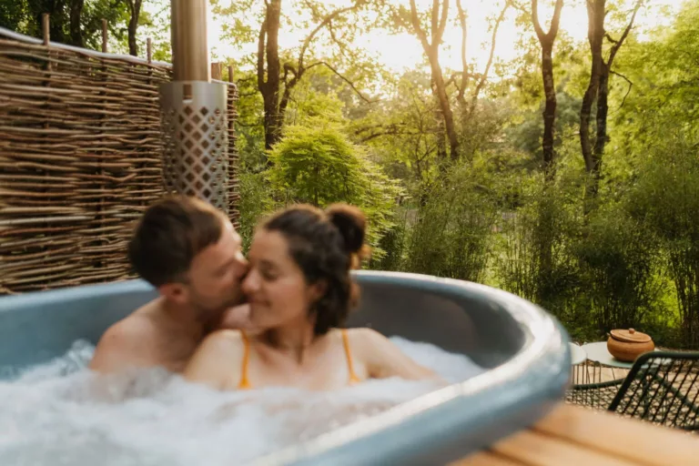 Couple en week-end en amoureux dans le bain nordique d'un écolodge du Domaine Toucan en Vendée