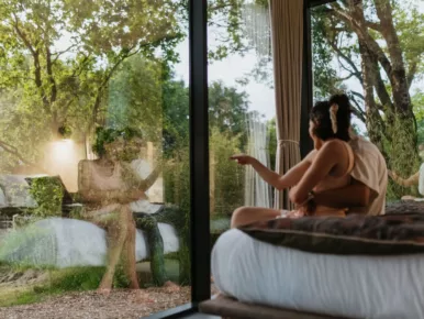 Couple contemplant la forêt depuis la chambre du Lodge Miroir, séjour insolite en Vendée
