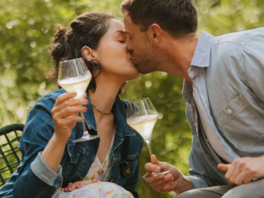 Couple s'embrassant avec une coupe de champagne au Lodge Miroir, week-end romantique en Vendée