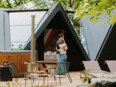 Couple enlacé devant le bain nordique chauffé au poêle à bois du Lodge Étoile