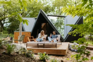 Couple se ressourçant sur les transats en terrasse devant le Lodge Étoile en Vendée