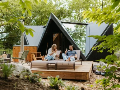 Couple se ressourçant sur les transats en terrasse devant le Lodge Étoile en Vendée