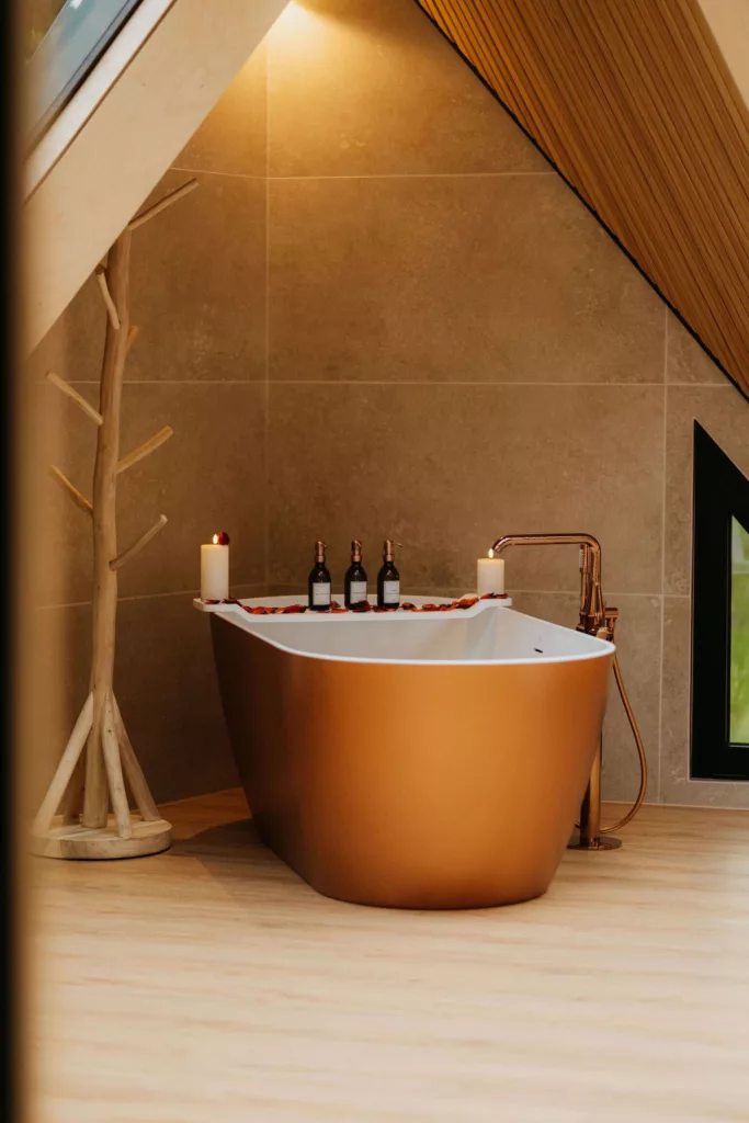 Baignoire îlot cuivrée du Lodge Étoile en ambiance romantique aux chandelles, séjour en amoureux en Vendée