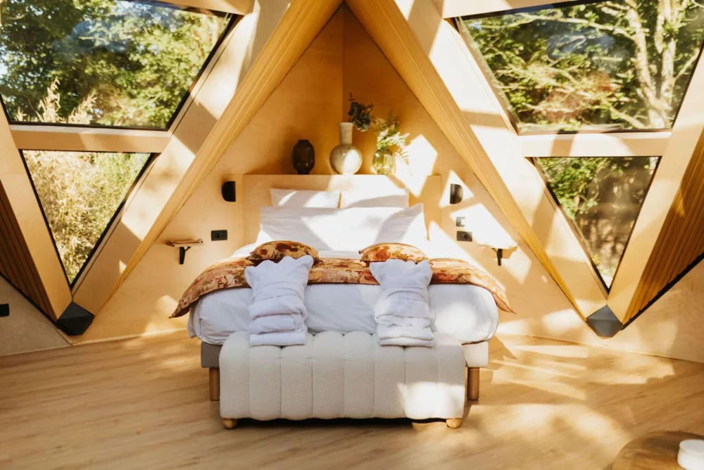 Chambre du Lodge Étoile avec lit face aux baies vitrées sur la nature