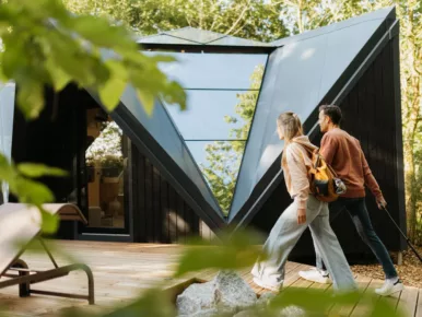 Couple découvrant la façade géodésique du Lodge Étoile, hébergement insolite au Poiré-sur-Vie