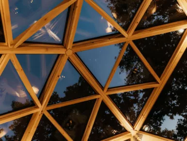Détail du plafond vitré géodésique du Lodge Étoile à la tombée de la nuit