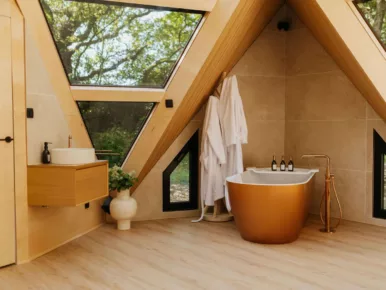 Salle de bain du Lodge Étoile avec baignoire îlot cuivrée et vue sur la nature
