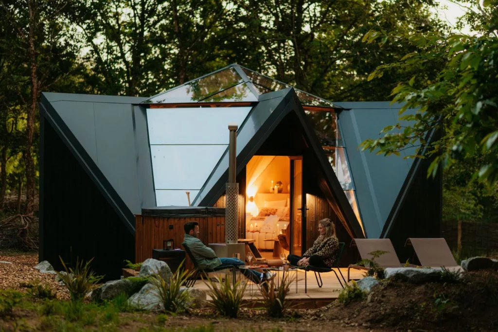 Lodge étoile de nuits avec couple qui se repose sur la terrasse en bois dans la nature au calme