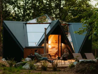 Lodge étoile de nuits avec couple qui se repose sur la terrasse en bois dans la nature au calme