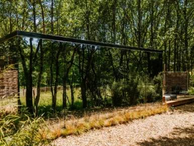 Lodge insolite miroir totalement vitré reflétant des arbres et la nature