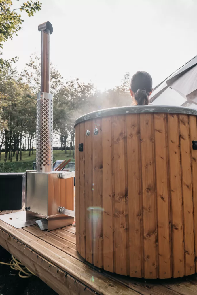 Bain nordique en bois chauffé au poêle à bois avec vapeur, sur la terrasse d'un écolodge du Domaine Toucan en Vendée