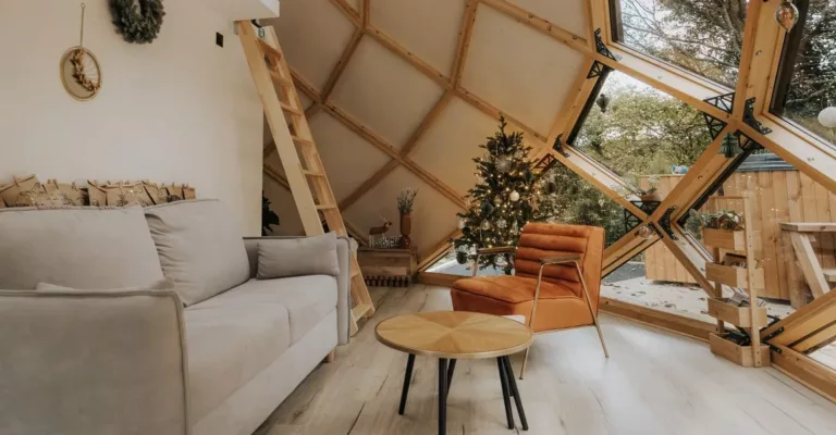 Hébergement insolite avec grande baie vitrée en forme de losange pour couple avec mezzanine décoré avec un sapin pour Noël