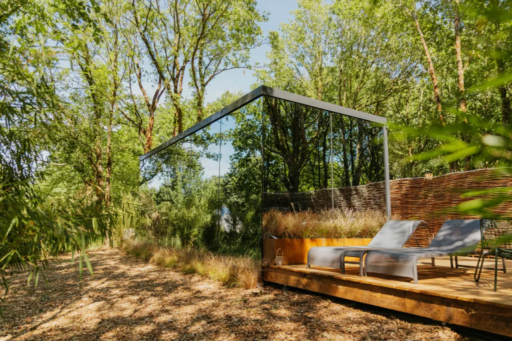 Lodge aux vitres à effet miroir avec végétation se reflétant dessus