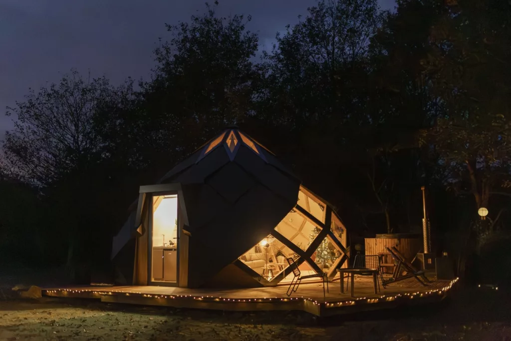 Le Zome illuminé la nuit avec guirlandes de Noël et bain nordique, écolodge insolite du Domaine Toucan en Vendée